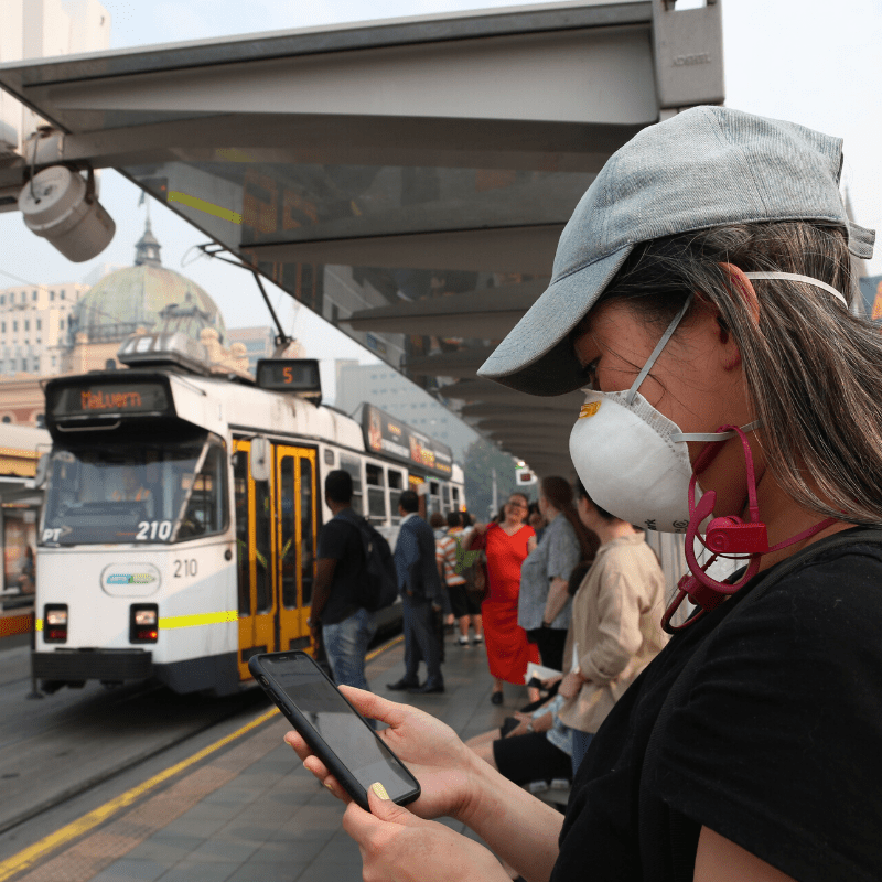 Young woman at Melbourne tram spot wearing a P1/P2 mask